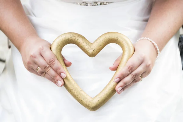 Невеста, держащая свадебный аксессуар в форме сердца — стоковое фото