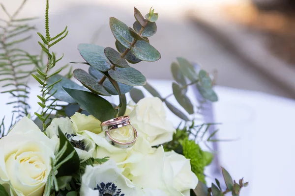 Bouquet mawar dan cincin tergeletak di atas meja — Stok Foto