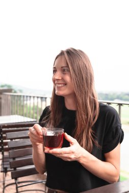 Fincan çay ve gülümseyen güzel genç kadın tutar