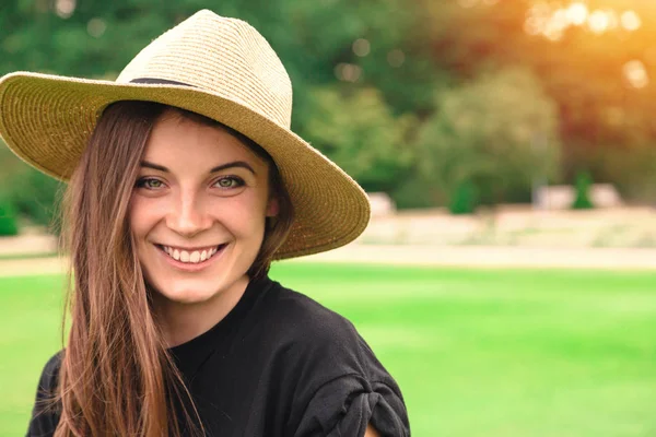 Молода красива жінка в солом'яному капелюсі в парку влітку — стокове фото