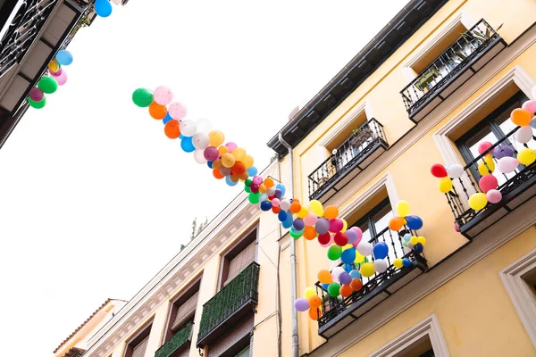 Bande de ballons colorés dans le ciel attachés au balcon — Photo