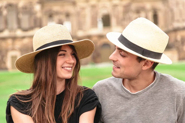 Joven pareja en forma se sientan juntos usando sombreros de paja — Foto de Stock