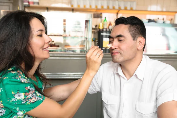 Junger Mann schenkt seiner Frau ein Stück Kuchen — Stockfoto