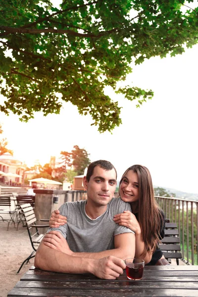 Junges schönes Paar teilt Tee am Gartentisch — Stockfoto