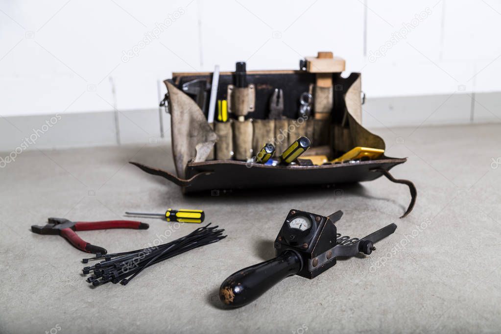 Box with electrician tools on leather background