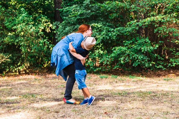 Mutter und Sohn spazieren gemeinsam im sonnigen Park — Stockfoto