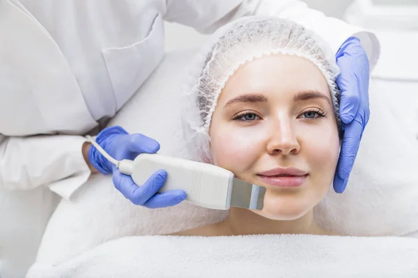 Kosmetyk wykonuje zabieg ultrasonograficzny na kobiecej twarzy — Zdjęcie stockowe