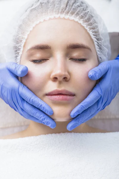 Młoda kobieta coraz twarzy masaż w salonie kosmetycznym — Zdjęcie stockowe
