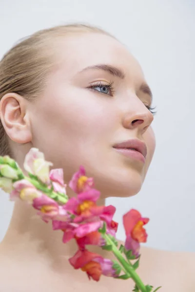 Beautiful girls face with color flower near — Stock Photo, Image