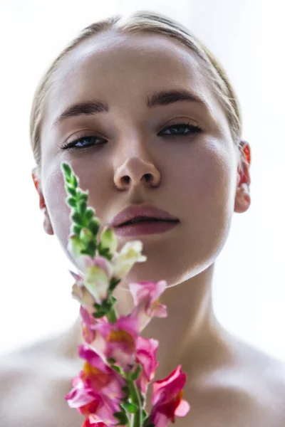 Hermosa joven oliendo flor de snapdragon brillante —  Fotos de Stock