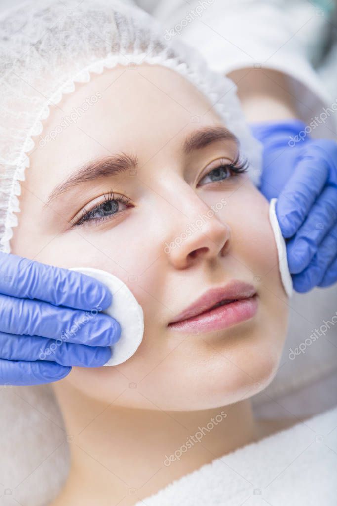 Young woman getting face procedure at salon