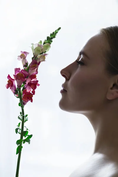 Face of young girl in profile sniffing flower — Stock Photo, Image