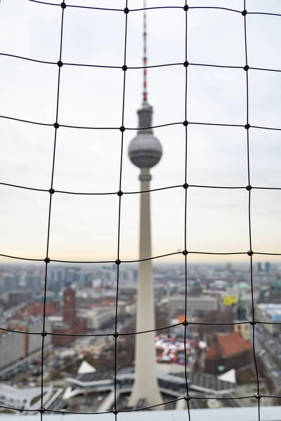 Vista da torre de TV Fernsehturm através de esgrima de malha — Fotografia de Stock