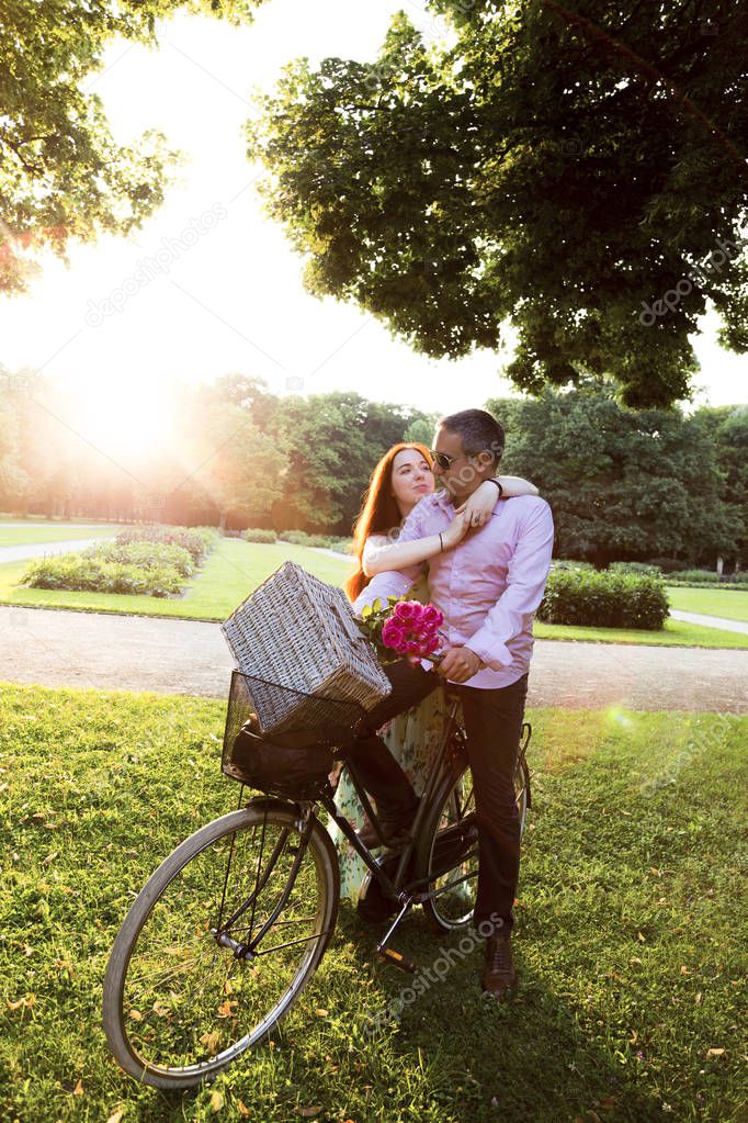 Romantic couple going on picnic in park by bike