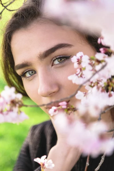 Портрет дівчини біля гілки рожевого квітучого дерева — стокове фото