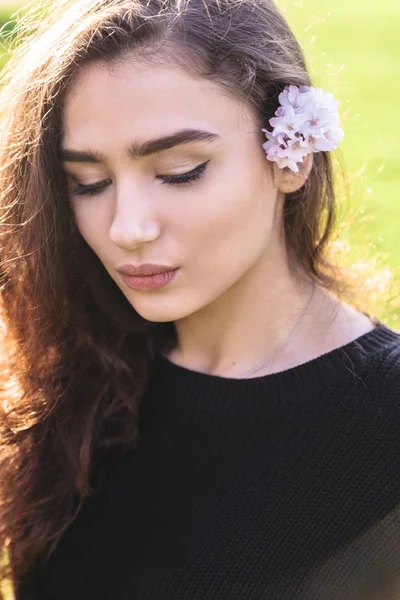 Mujer joven con flor rosa escondida detrás de su oreja — Foto de Stock