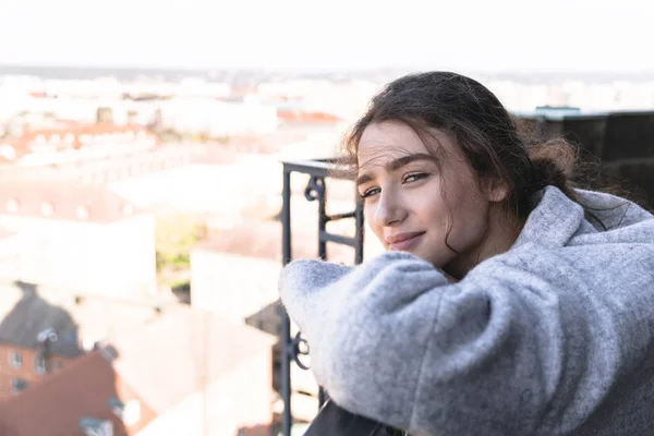 Menina de pé na varanda, inclinando-se sobre trilhos de ferro — Fotografia de Stock