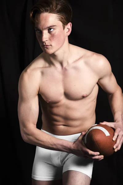 Rugby player in studio prepared to throw ball — Stock Photo, Image