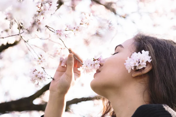 Kız gülümsüyor ve Blossom şube çiçek kokur