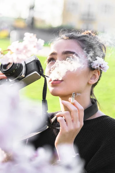 Chica toma fotos y fuma, mirando hacia otro lado — Foto de Stock