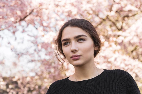 Retrato de mujer joven en perfil por árbol de flores — Foto de Stock