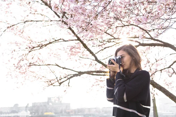 Chica hace la imagen mientras está de pie bajo el árbol — Foto de Stock