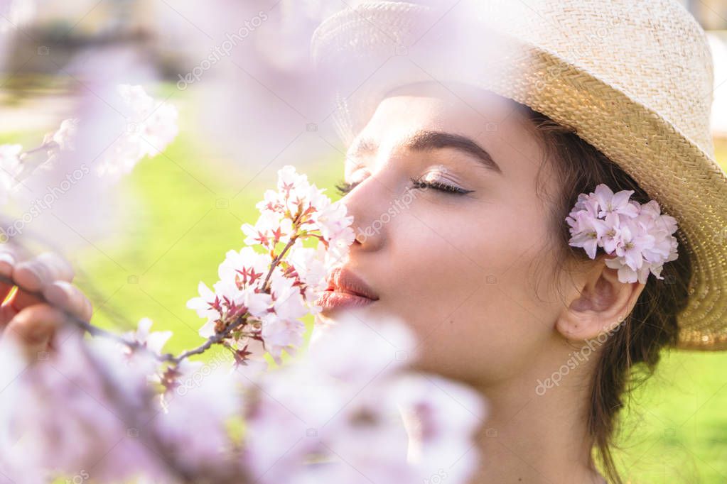 Girl in straw hat with flowers behind ear outdoor