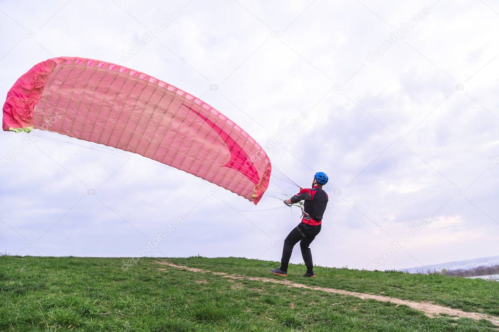 Man lowers paraglider to ground after landing
