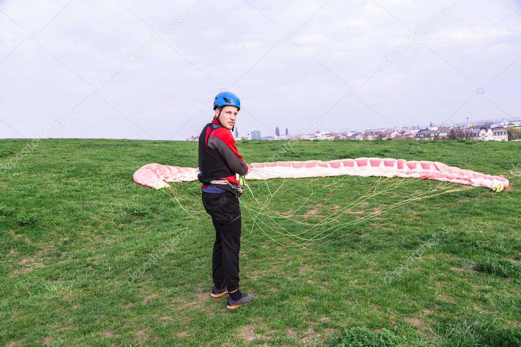Man landed and folds parachute lying on ground