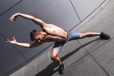 Genç kaslı adam kollar ile dans kaldırdı