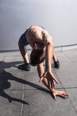 Dans dansçı kavisli poz kullanır ve yere dokunur