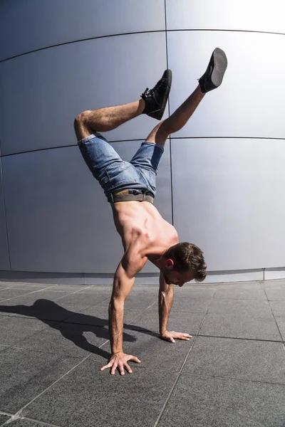 Hombre joven en pantalones vaqueros breakdancing al aire libre —  Fotos de Stock