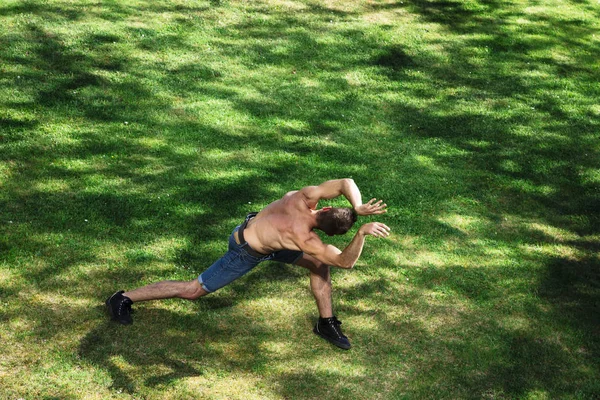 Homem atlético dança na natureza retratando animal — Fotografia de Stock