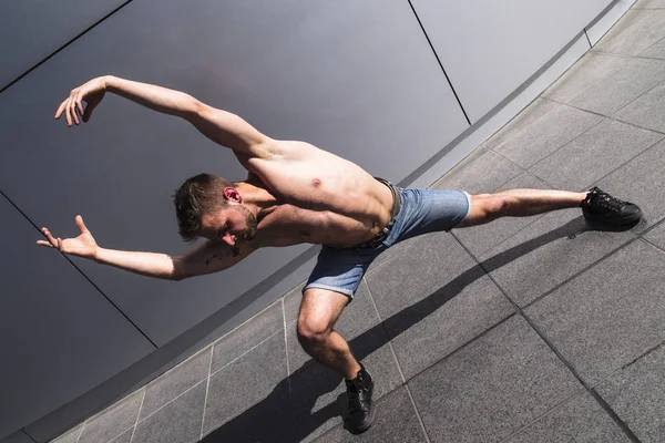 Genç kaslı adam kollar ile dans kaldırdı