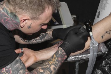 Dövme ustası erkek elinde siyah dövme yapar