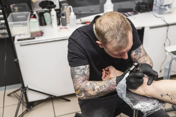 Молода блондинка татуювання художник робить татуювання в салоні — стокове фото