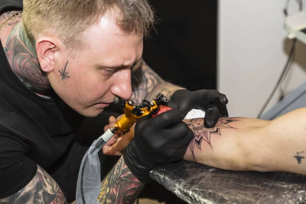 Татуювання робить татуювання на руці чоловіка крупним планом — стокове фото