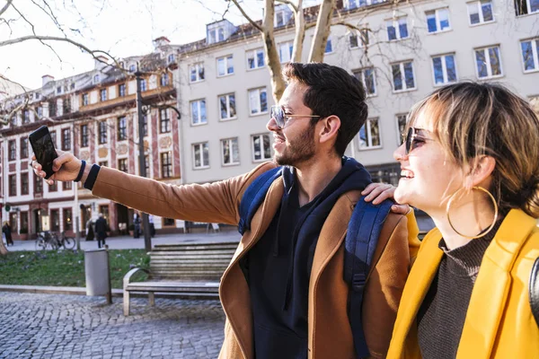 stock image Guy and girl doing selfie in phone and smiling