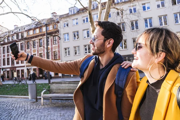 Stock image Guy and girl doing selfie in phone and smiling