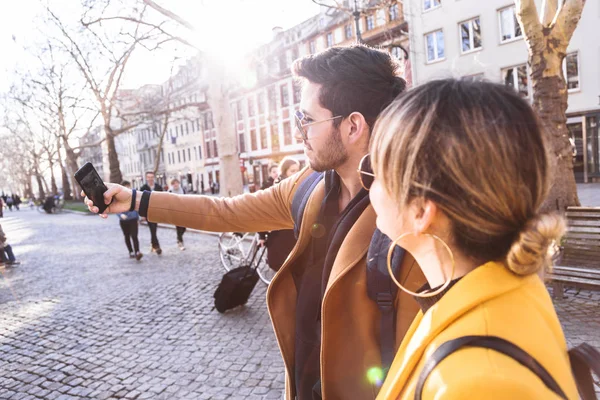 Young beautiful guy and girl doing selfie in phone