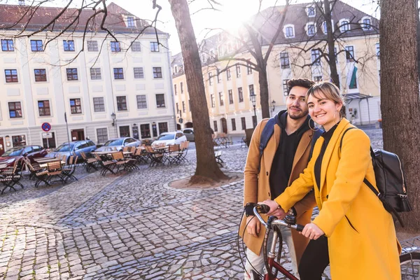 Jovem casal multicultural sorridente com bicicleta olhando na câmera — Fotografia de Stock