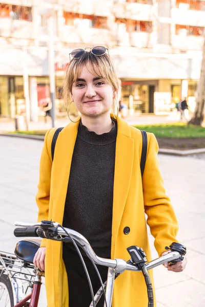 Jovem mulher e bicicleta na rua da cidade em dia ensolarado — Fotografia de Stock