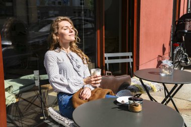 Genç kadın keman ve hayalleri ile kafede oturur