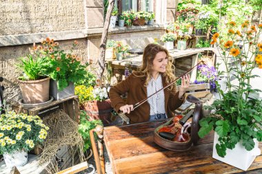 Bitkiler arasında bahçede Kız keman için yay ayarlar