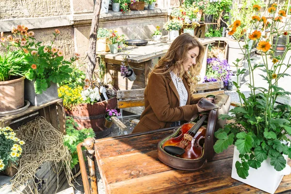 Kız müzisyen çantasından keman çıkardı