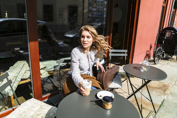 Menina senta-se no café com violinos e bebidas de café — Fotografia de Stock