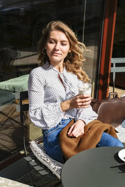 Kemanlı genç kız şehir kafede kahve içiyor