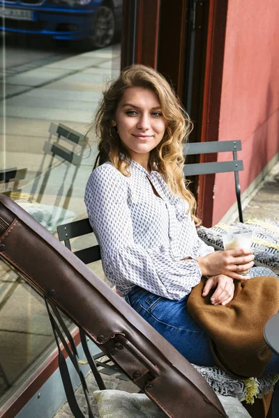 Giovane donna seduta a tavola in caffè con violino — Foto Stock