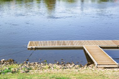 Arka planda mavi göl veya nehir ile ahşap iskele