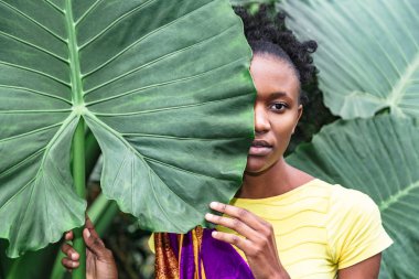 Afrikalı kız yeşil yaprakla yüzünün yarısını kapladı